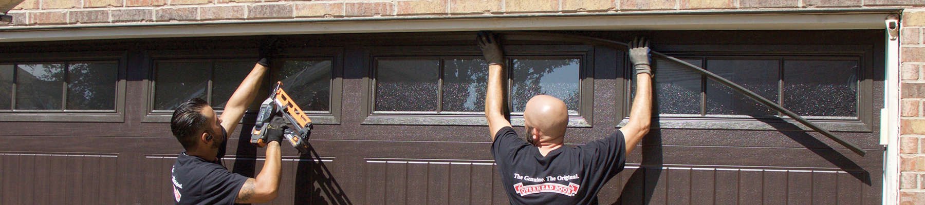 two technicians installing a garage door